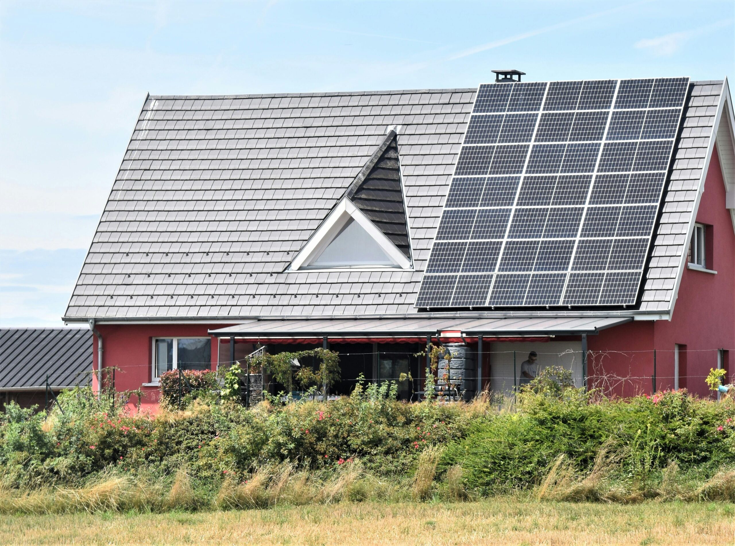 pexels-photo-17893477-17893477 A red house with solar panels on the roof in Seppois-le-Bas, illustrating clean energy.